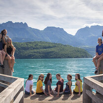 High School Semester Abroad! line of people sitting at edge of ledge looking out over blue ocean
